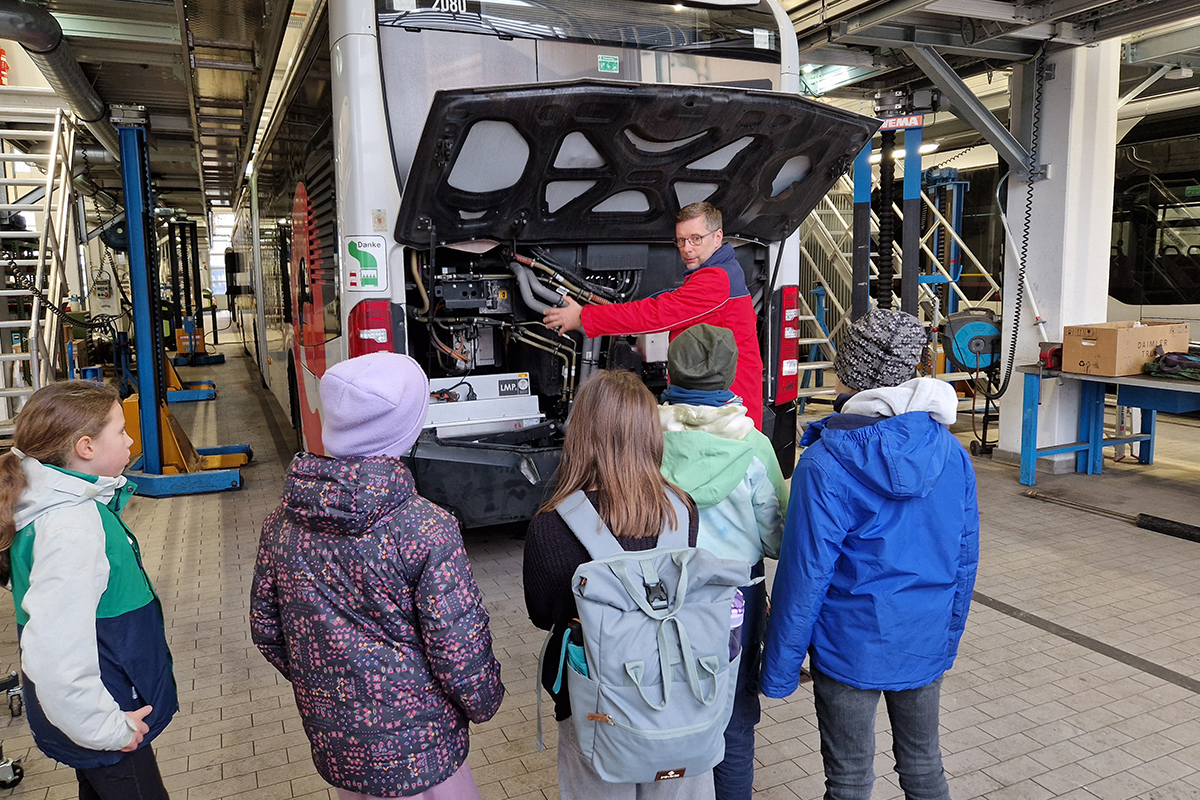 Fünf Grundschülerinnen bei der Betriebshofführung in der Werkstatt von vhh.mobility.