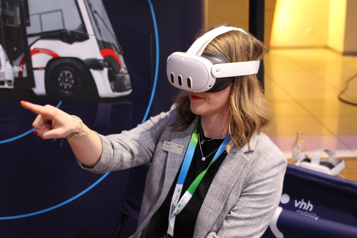 Die Besucherin erlebt über eine VR-Brille eine virtuelle Fahrt mit dem autonomen ahoi Shuttle.